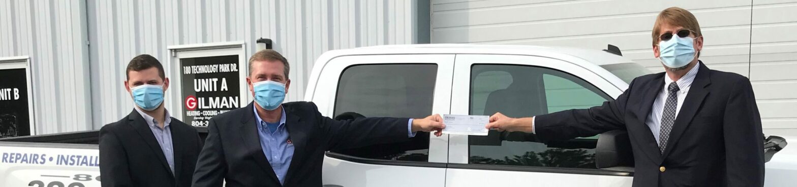 People in front of Truck holding donation check