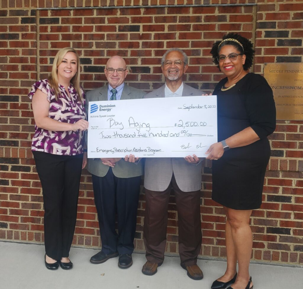 Four people holding large check