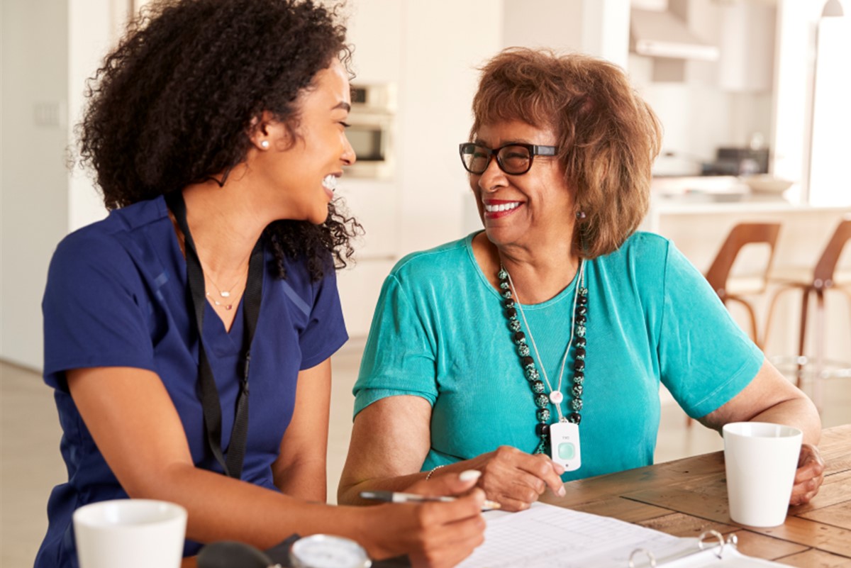 Female health worker chats with older woman